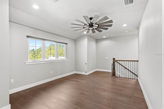 empty room with a textured ceiling, dark hardwood / wood-style floors, and ceiling fan