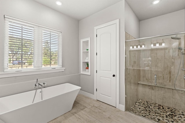 bathroom featuring wood-type flooring and independent shower and bath