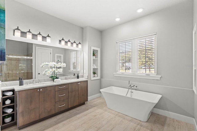 bathroom featuring hardwood / wood-style flooring, plus walk in shower, and vanity