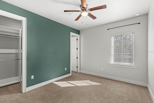 unfurnished bedroom featuring ceiling fan, light carpet, a textured ceiling, and a closet