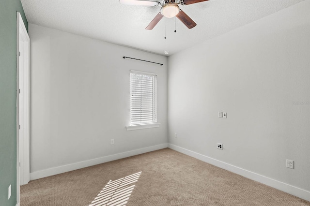 carpeted empty room with ceiling fan and a textured ceiling