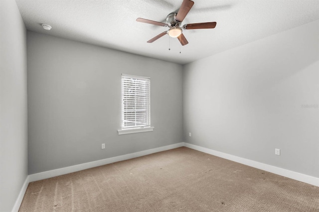 carpeted spare room with a textured ceiling and ceiling fan