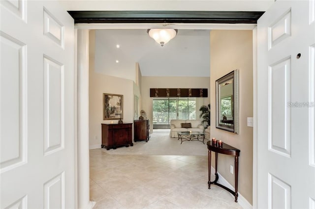 hallway featuring light tile patterned flooring and high vaulted ceiling