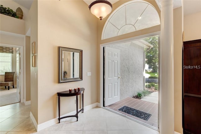 tiled entrance foyer with a towering ceiling and plenty of natural light