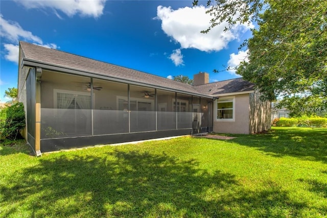 back of house featuring ceiling fan, a yard, and a sunroom