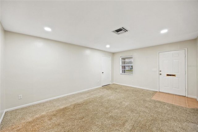 unfurnished room featuring light colored carpet, visible vents, and baseboards