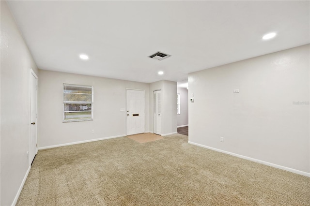 empty room featuring light carpet, visible vents, recessed lighting, and baseboards