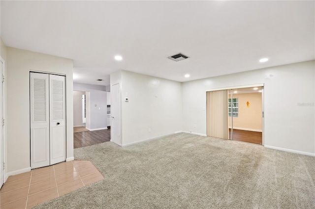 tiled spare room featuring recessed lighting, visible vents, carpet flooring, and baseboards