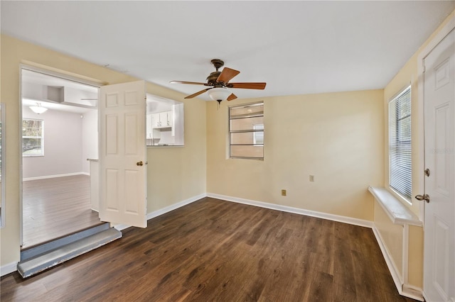 unfurnished room featuring dark wood-type flooring, baseboards, and ceiling fan