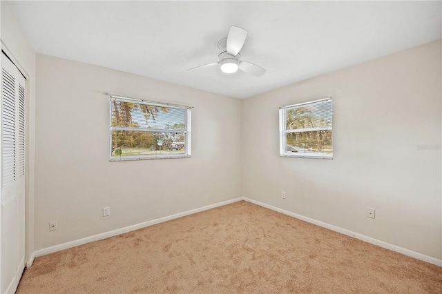 unfurnished bedroom featuring a ceiling fan, carpet, a closet, and baseboards