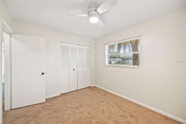 unfurnished bedroom featuring a closet, baseboards, a ceiling fan, and carpet flooring