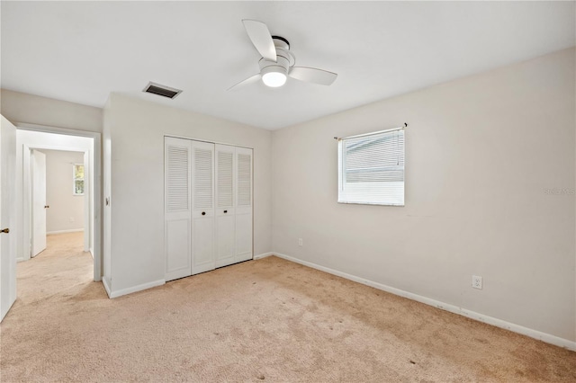 unfurnished bedroom with a closet, visible vents, multiple windows, and carpet