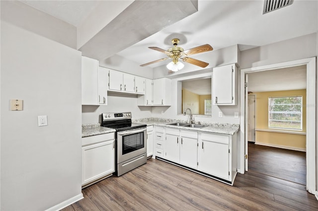 kitchen with visible vents, stainless steel range with electric cooktop, wood finished floors, and a sink