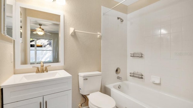 full bathroom featuring toilet, vanity, tiled shower / bath, and ceiling fan