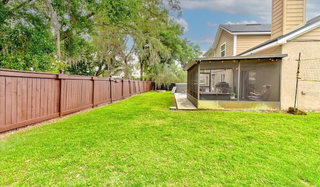 view of yard with a sunroom and a fenced backyard