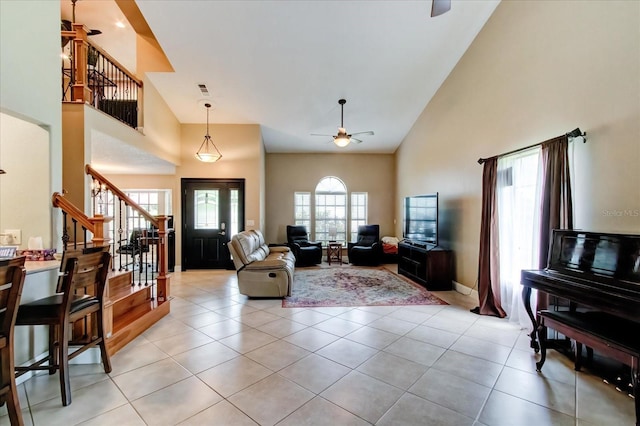 living room with high vaulted ceiling, light tile patterned flooring, and stairs