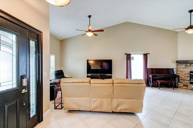 living area featuring light tile patterned floors, a brick fireplace, high vaulted ceiling, and a ceiling fan