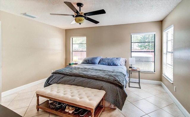 bedroom with light tile patterned floors, multiple windows, and a textured ceiling