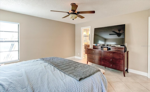 bedroom with a ceiling fan, a textured ceiling, baseboards, and light tile patterned floors