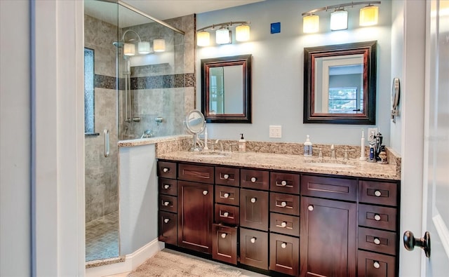 bathroom featuring a stall shower, a sink, and double vanity