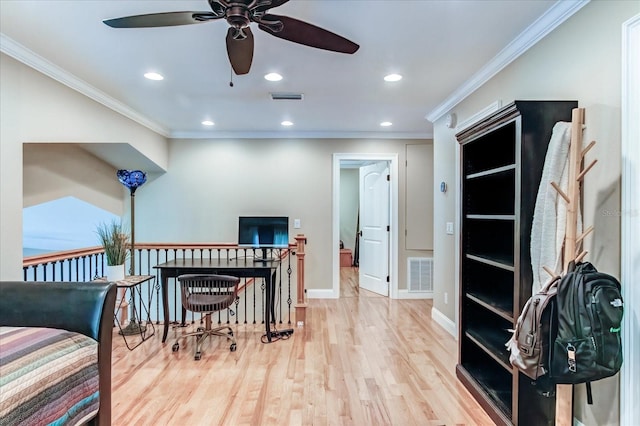 sitting room with light wood finished floors, baseboards, visible vents, and crown molding