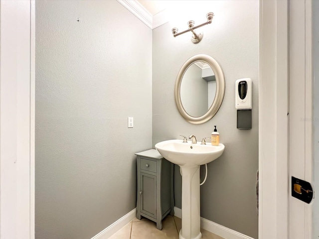 bathroom featuring ornamental molding, tile patterned flooring, a sink, and baseboards