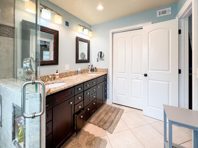 bathroom with double vanity, visible vents, a sink, and tile patterned floors