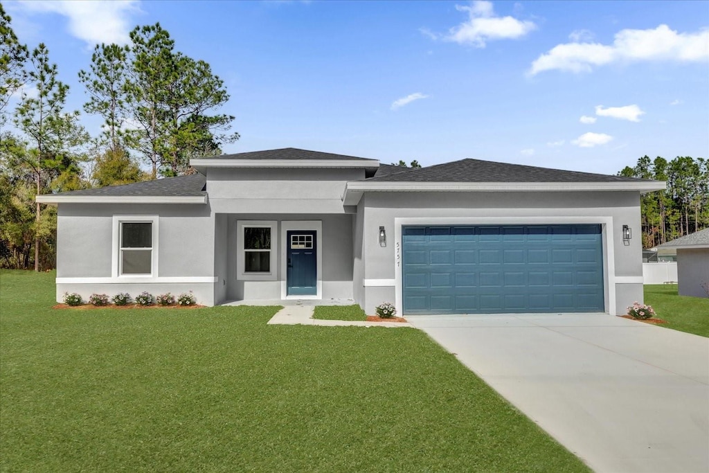 prairie-style house with a garage and a front lawn