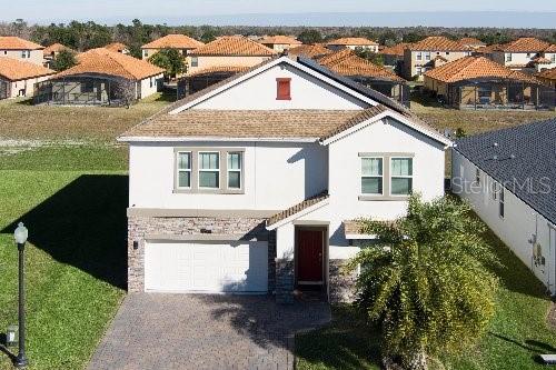 mediterranean / spanish-style home featuring a garage and a front yard