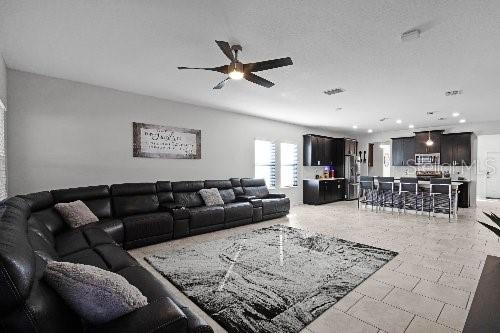 living room with a textured ceiling and ceiling fan