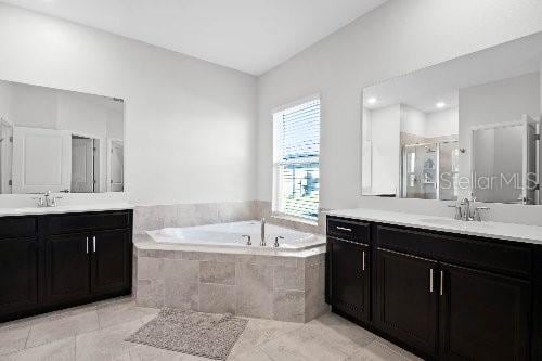 bathroom featuring tile patterned flooring, vanity, and shower with separate bathtub