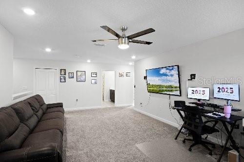 interior space with ceiling fan and a textured ceiling