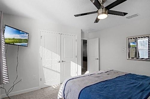 carpeted bedroom with a closet and ceiling fan