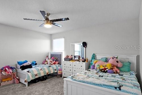 bedroom with ceiling fan, a textured ceiling, and carpet