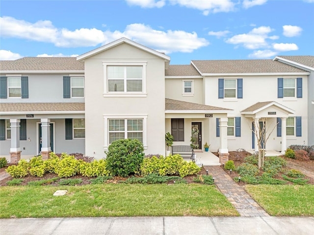 townhome / multi-family property featuring a front lawn