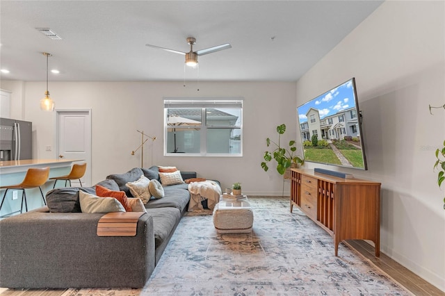 living room featuring ceiling fan and light hardwood / wood-style flooring