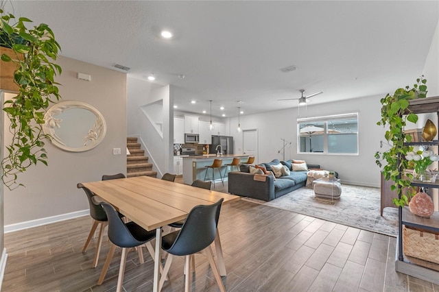 dining area with sink, hardwood / wood-style floors, and ceiling fan