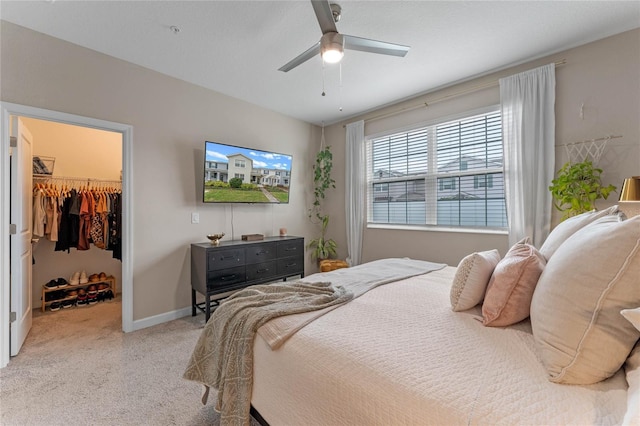 carpeted bedroom with ceiling fan, a spacious closet, and a closet