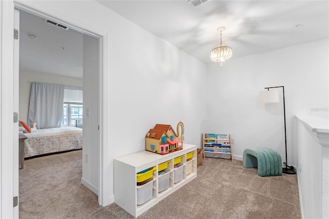 playroom with light colored carpet and an inviting chandelier