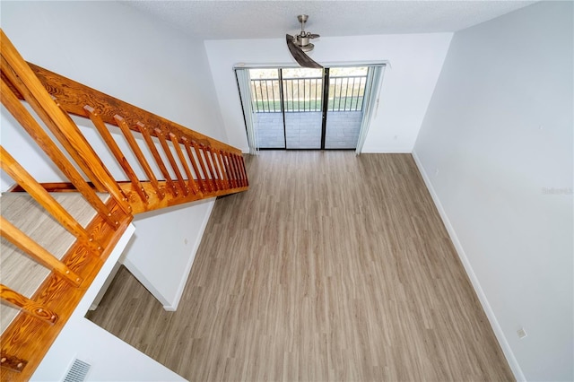 unfurnished living room with a textured ceiling and light wood-type flooring