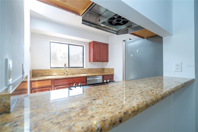 kitchen featuring appliances with stainless steel finishes, light stone countertops, and sink