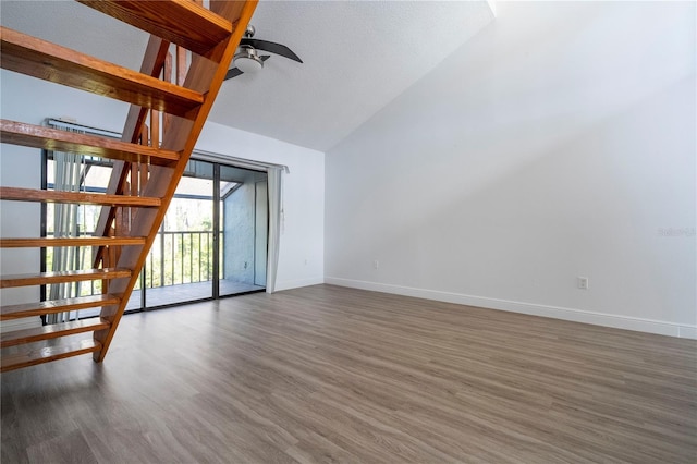 unfurnished living room featuring dark wood-type flooring, high vaulted ceiling, and ceiling fan