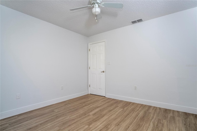 empty room with ceiling fan, a textured ceiling, and light hardwood / wood-style floors