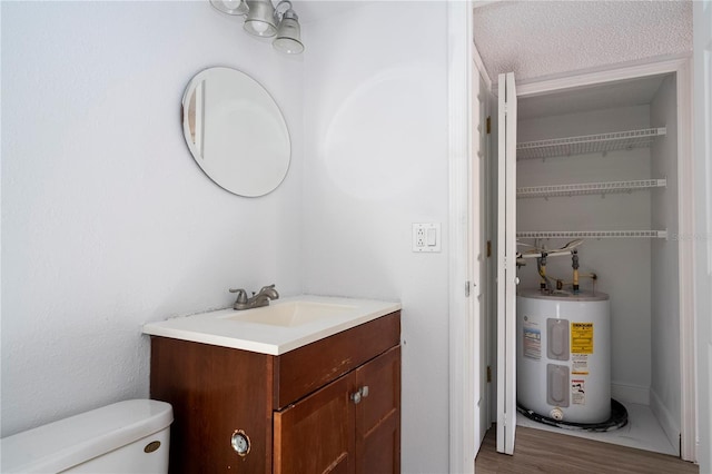 bathroom featuring vanity, toilet, hardwood / wood-style floors, and water heater