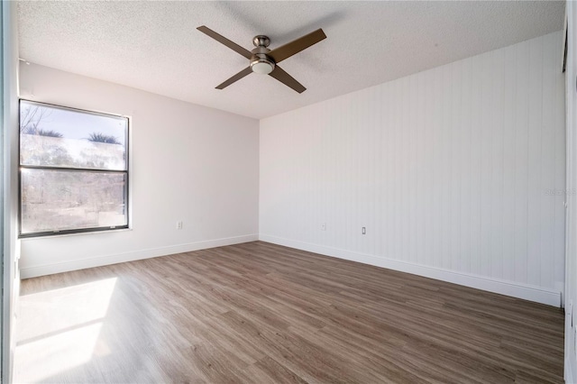 unfurnished room with dark wood-type flooring, ceiling fan, and a textured ceiling