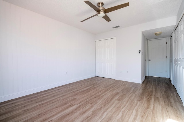 unfurnished bedroom with ceiling fan, a textured ceiling, and light hardwood / wood-style floors