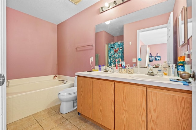 bathroom with tile patterned flooring, tiled tub, vanity, and toilet