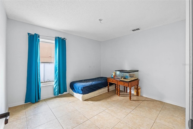 bedroom with a textured ceiling and light tile patterned floors