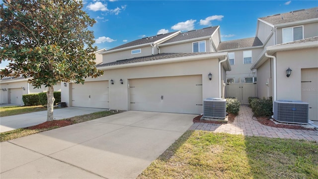 view of front of house featuring a garage and central air condition unit