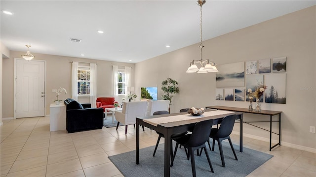 dining space featuring light tile patterned flooring and a notable chandelier